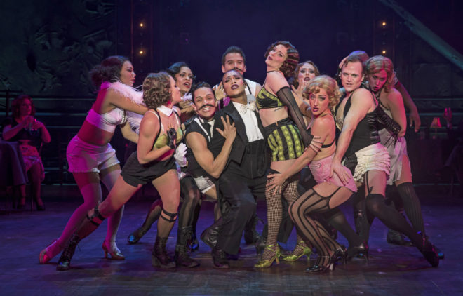 Joseph Anthony Byrd (center, tux) plays the Emcee and Kelly Felthous (black and green striped shorts w/fishnets) plays Sally Bowles in Paramount Theatre’s Cabaret. Photo credit: Liz Lauren